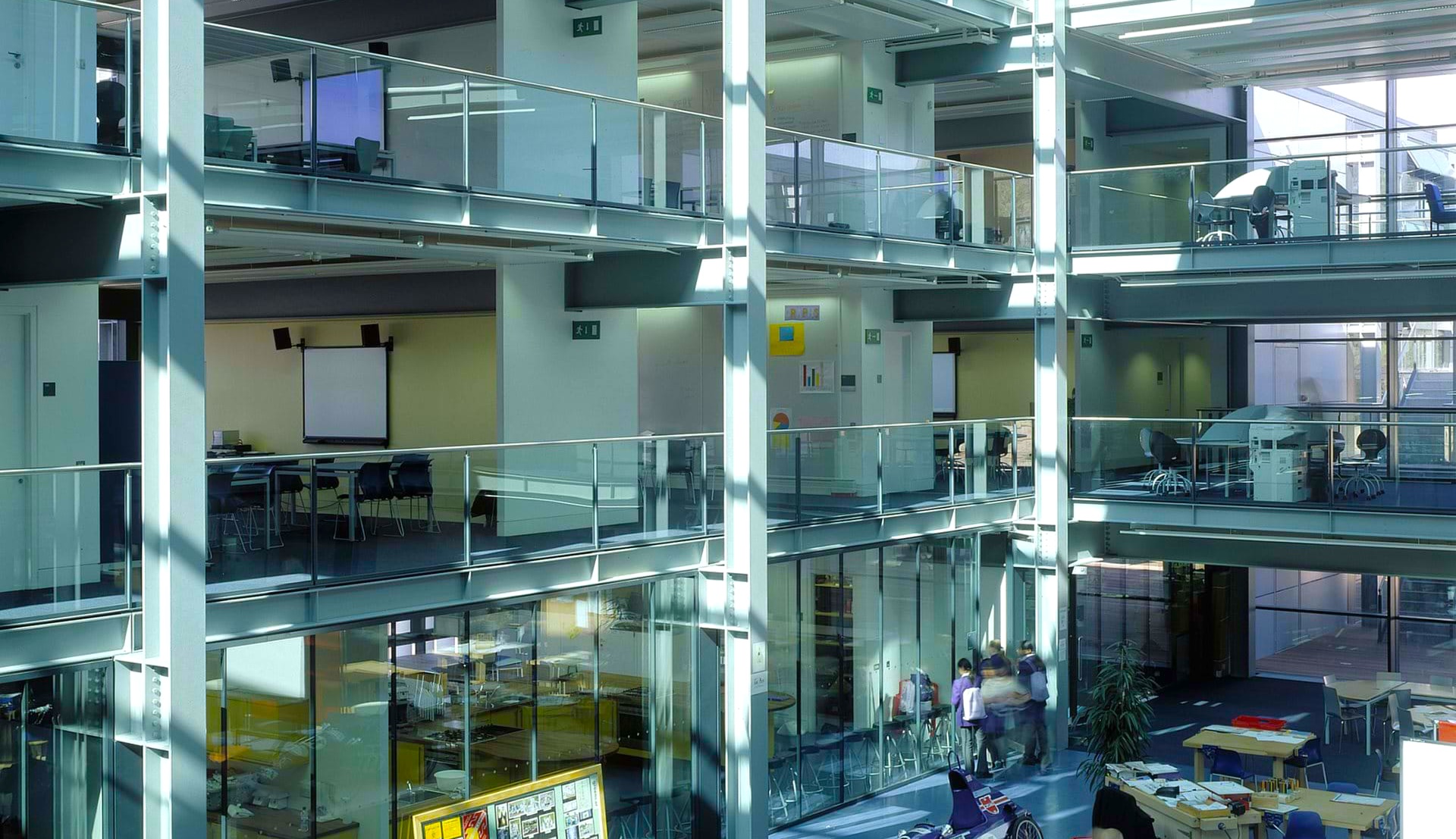 Hatalmas, modern iskolai átrium kezeletlen akusztikai felületekkel – a brit iskolai zajbotrány tipikus helyszíne.